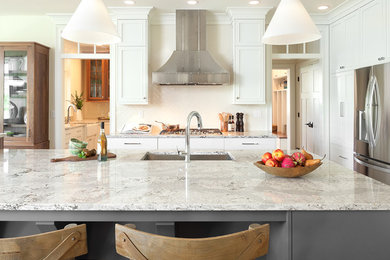 Example of a large arts and crafts single-wall medium tone wood floor and brown floor eat-in kitchen design in Grand Rapids with an undermount sink, quartz countertops, white backsplash, ceramic backsplash, stainless steel appliances and an island