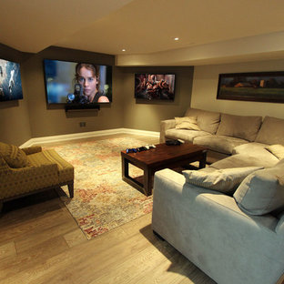 Idées déco pour une salle de cinéma classique de taille moyenne et ouverte avec un mur beige, sol en stratifié, un téléviseur fixé au mur et un sol marron.