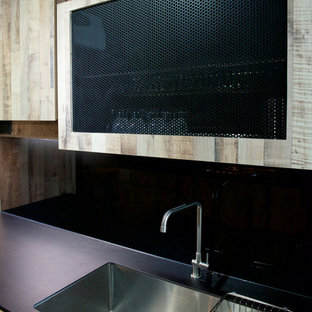 Industrial kitchen pantry designs - Inspiration for an industrial kitchen pantry remodel in Singapore with a single-bowl sink, medium tone wood cabinets, black backsplash and glass sheet backsplash