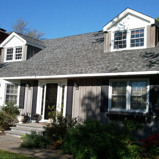 Bild på ett mellanstort lantligt grått trähus, med två våningar