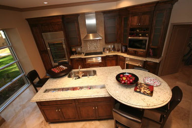 Kitchen - mid-sized traditional l-shaped ceramic tile and beige floor kitchen idea in Phoenix with a farmhouse sink, shaker cabinets, dark wood cabinets, granite countertops, beige backsplash, ceramic backsplash, stainless steel appliances and two islands
