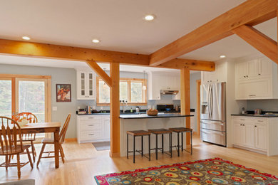 Mid-sized country l-shaped light wood floor and beige floor open concept kitchen photo in Burlington with beaded inset cabinets, white cabinets, soapstone countertops, stainless steel appliances and an island