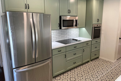 Inspiration for a vinyl floor kitchen remodel in Dallas with shaker cabinets, green cabinets, quartz countertops, white backsplash, porcelain backsplash and white countertops