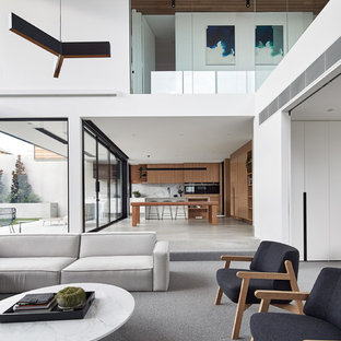 This is an example of a modern open concept family room in Melbourne with white walls, carpet and grey floor.