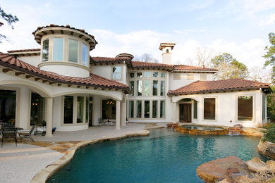 Large mountain style backyard concrete and custom-shaped natural hot tub photo in Houston