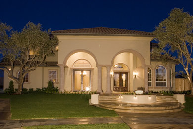 Mid-sized tuscan beige two-story stucco house exterior photo in Other with a hip roof and a tile roof