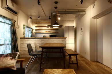 This is an example of a small modern open plan dining in Kobe with white walls, medium hardwood floors and brown floor.