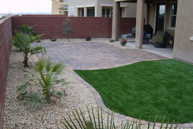 This is an example of a mid-sized traditional drought-tolerant and full sun backyard brick landscaping in Las Vegas for summer.