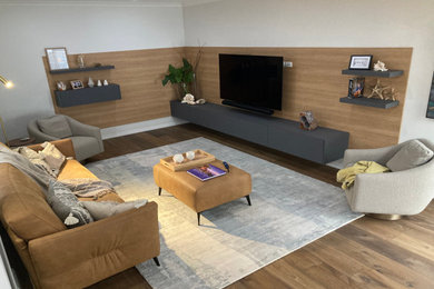 Photo of a large beach style formal open concept living room in Perth with multi-coloured walls, dark hardwood floors, a built-in media wall, brown floor and decorative wall panelling.