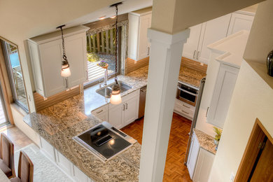 Kitchen - transitional medium tone wood floor kitchen idea with an undermount sink, shaker cabinets, white cabinets, granite countertops, brown backsplash, stainless steel appliances and a peninsula