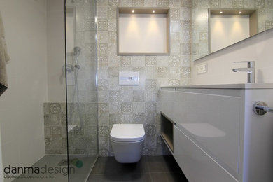 Modelo de cuarto de baño principal nórdico pequeño con ducha abierta, sanitario de pared, baldosas y/o azulejos blancos, suelo de azulejos de cemento, lavabo bajoencimera y suelo gris