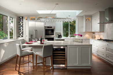 Design ideas for a mid-sized transitional l-shaped eat-in kitchen in Vancouver with recessed-panel cabinets, grey cabinets, wood benchtops, beige splashback, stainless steel appliances, dark hardwood floors, with island and brown floor.