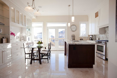 Inspiration for a large transitional l-shaped porcelain tile and beige floor eat-in kitchen remodel in Toronto with an undermount sink, recessed-panel cabinets, white cabinets, granite countertops, multicolored backsplash, ceramic backsplash, stainless steel appliances and an island