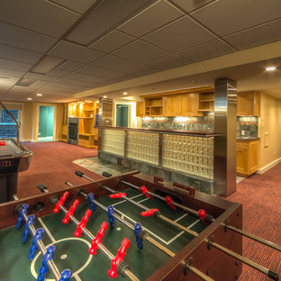 Design ideas for a large classic walk-out basement in New York with beige walls, carpet, a standard fireplace and red floors.