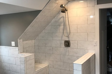 Large minimalist master gray tile and stone tile single-sink, dark wood floor and brown floor wet room photo in New York with shaker cabinets, white cabinets, an undermount sink, a hinged shower door, gray countertops, a freestanding vanity, a two-piece toilet and gray walls