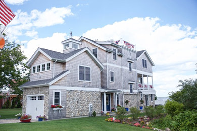 Photo of a large beach style three-storey beige exterior in Providence with wood siding and a gable roof.