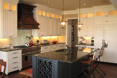 Large traditional l-shaped kitchen in Dallas with with island, raised-panel cabinets, white cabinets, granite benchtops, beige splashback, stone tile splashback, stainless steel appliances, an undermount sink and dark hardwood floors.