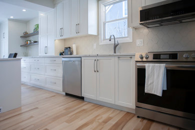 Eat-in kitchen - mid-sized contemporary galley light wood floor eat-in kitchen idea in Other with an undermount sink, shaker cabinets, white cabinets, quartz countertops, white backsplash, porcelain backsplash, stainless steel appliances, an island and white countertops