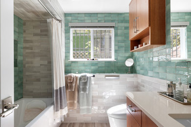 Inspiration for a mid-sized transitional green tile and ceramic tile porcelain tile, brown floor and single-sink bathroom remodel in Seattle with flat-panel cabinets, medium tone wood cabinets, a wall-mount toilet, multicolored walls, an undermount sink, quartz countertops, beige countertops and a built-in vanity