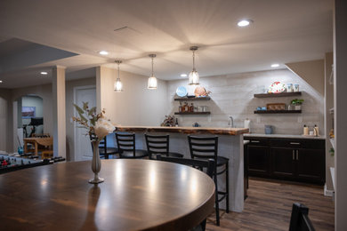 Inspiration for a large timeless galley vinyl floor and brown floor seated home bar remodel in Detroit with an undermount sink, flat-panel cabinets, dark wood cabinets and granite countertops