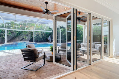 Inspiration for a huge contemporary backyard concrete paver patio remodel in Tampa with a roof extension