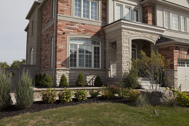 This is an example of a mid-sized traditional full sun front yard concrete paver driveway in Other for summer.