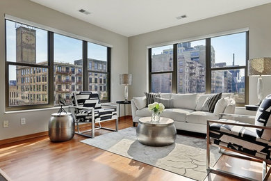 Transitional medium tone wood floor and brown floor living room photo in Minneapolis with gray walls