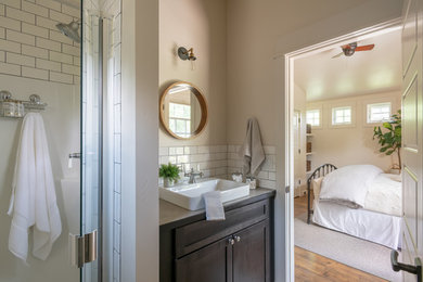 Example of a small transitional 3/4 white tile and subway tile medium tone wood floor and brown floor alcove shower design in Other with shaker cabinets, dark wood cabinets, beige walls, a vessel sink, laminate countertops, a hinged shower door and beige countertops