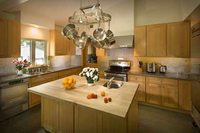 Inspiration for a mid-sized craftsman u-shaped concrete floor open concept kitchen remodel in San Francisco with a double-bowl sink, flat-panel cabinets, light wood cabinets, granite countertops, gray backsplash, stone slab backsplash, stainless steel appliances and an island