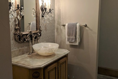 Bathroom - mid-sized traditional 3/4 beige tile and porcelain tile limestone floor and gray floor bathroom idea in Dallas with furniture-like cabinets, medium tone wood cabinets, beige walls, a vessel sink, quartzite countertops and beige countertops