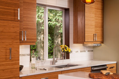 Mid-century modern dark wood floor and brown floor kitchen photo in Seattle with flat-panel cabinets, medium tone wood cabinets, quartz countertops, white backsplash and white countertops