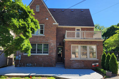 Elegant brown two-story house exterior photo in Detroit with a shingle roof and a brown roof