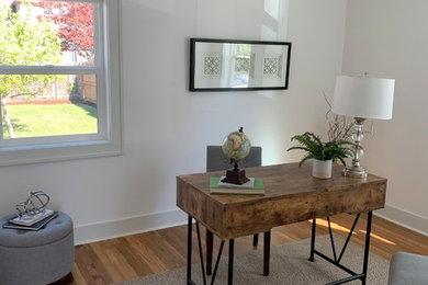 Home office - contemporary brown floor home office idea in Portland with white walls