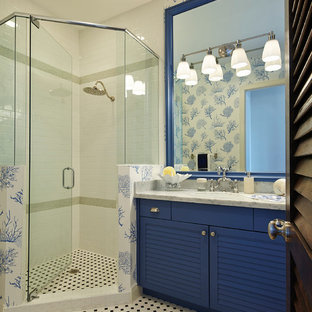 Exemple d'une salle de bain bord de mer avec un placard à porte persienne, des portes de placard bleues et une douche d'angle.