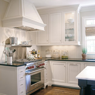 Große Klassische Küche in U-Form mit Vorratsschrank, Unterbauwaschbecken, Schrankfronten mit vertiefter Füllung, weißen Schränken, Mineralwerkstoff-Arbeitsplatte, Küchenrückwand in Weiß, Elektrogeräten mit Frontblende, braunem Holzboden und Kücheninsel in Atlanta