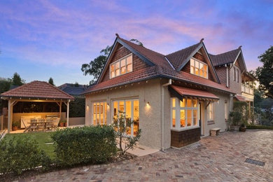 Large traditional two-storey stucco beige exterior in Sydney with a gable roof.