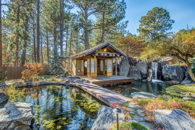 Design ideas for a huge asian partial sun backyard stone landscaping in Denver.