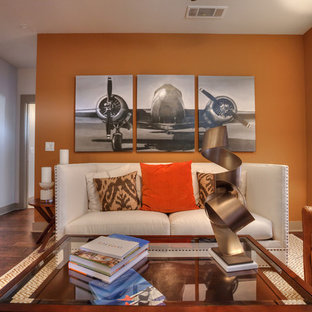 Ispirazione per un piccolo soggiorno chic aperto con pareti arancioni, parquet scuro e TV a parete