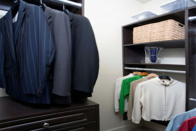 Example of a large classic men's carpeted walk-in closet design in Edmonton with open cabinets and dark wood cabinets