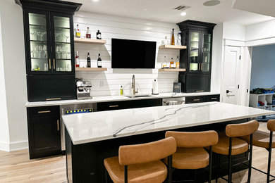 Inspiration for a mid-sized contemporary galley vinyl floor and beige floor seated home bar remodel in New York with an undermount sink, flat-panel cabinets, black cabinets, quartz countertops, white backsplash, shiplap backsplash and white countertops