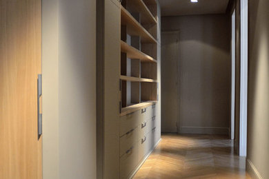 Large contemporary foyer in Paris with beige walls and light hardwood floors.