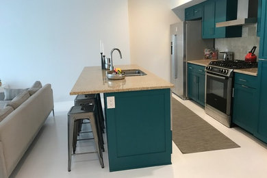Example of a mid-sized transitional single-wall kitchen design in Austin with an undermount sink, shaker cabinets, blue cabinets, granite countertops, gray backsplash, stainless steel appliances and an island