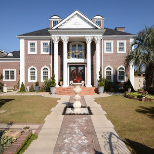 他の地域のトラディショナルスタイルのおしゃれな家の外観 (レンガサイディング、茶色い外壁、瓦屋根) の写真