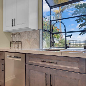 Bright Kitchen Sink Area with Herringbone Backsplash and Quartz Countertops