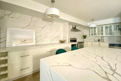 Inspiration for a small transitional u-shaped laminate floor and beige floor eat-in kitchen remodel in Toronto with shaker cabinets, quartz countertops, white backsplash, quartz backsplash and an island