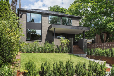 Mid-sized modern brown two-story wood exterior home idea in Toronto with a hip roof