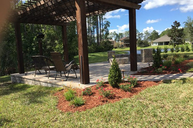 Inspiration for a mid-sized patio in Jacksonville with a fire feature, concrete pavers and a pergola.