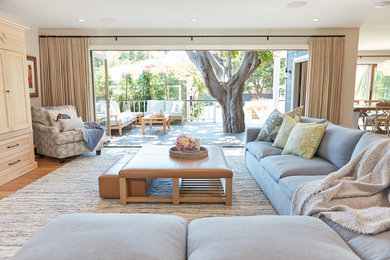 Example of a large trendy open concept light wood floor living room design in Los Angeles with a concealed tv