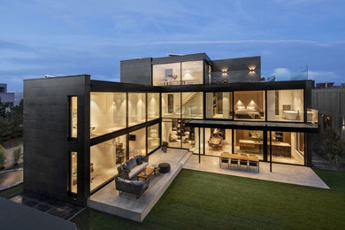Imagen de fachada de casa marrón minimalista grande de tres plantas con revestimiento de piedra y tejado plano