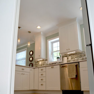 Fresh kitchen makeover with white shaker cabinets, tile backsplash, and pendants
